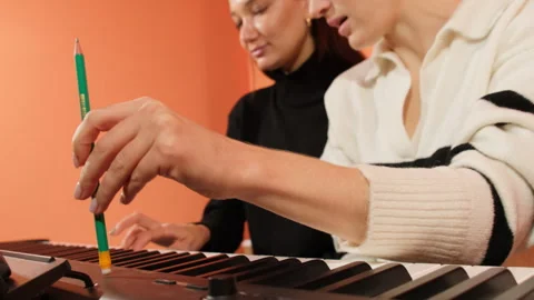 Teacher rhythmic tapping serves as accompaniment for lady playing Stock Footage 307018148