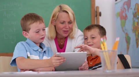 Teacher at school uses digital tablet in classroom Stock-Footage 62344245