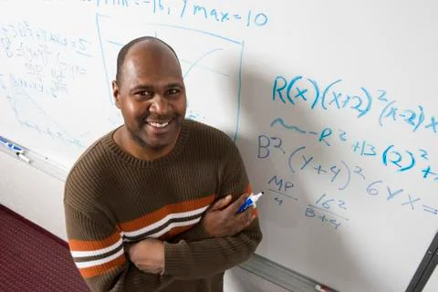 Teacher Solving Math's Equations On Whiteboard Stock Photos