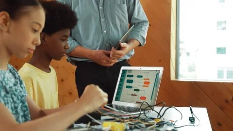 Teacher standing while explain coding and robotic construction. Edification. Stock Photos