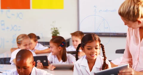 Teacher stepping into class guiding braided-hair student on tablet with math Stock Footage 312348428