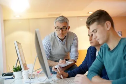 Teacher with students in computing class Stock Photos