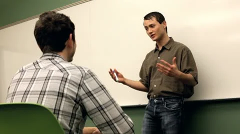 Teacher talking to student in classroom Vídeos de archivo 10699463