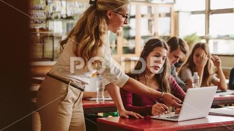 Teacher talking to student in classroom Stock Photos