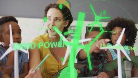 Teacher tapping tablet, guiding three boys spinning turbines as green overlays Stock Footage 333540171