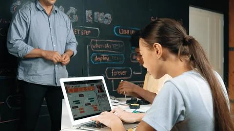 Teacher teach about coding system while student fixing main board. Edification. Stock-Fotos