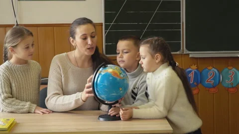 The teacher teaches children using the globe Stock Footage 102086248