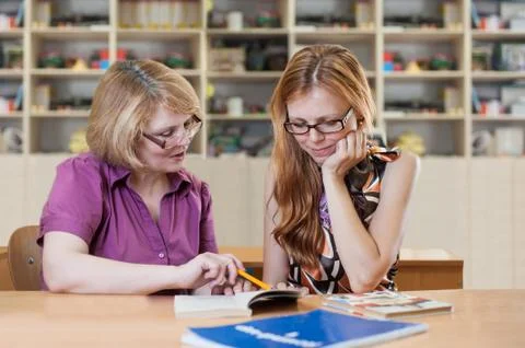 Teacher teaches a student at a table in the classroom Stock Photos