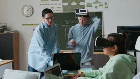 Teacher Teaching Boy to Use VR Glasses During IT Classes in School 스톡 동영상 317641904