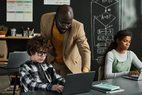Teacher teaching children to work with computer Stock Photos
