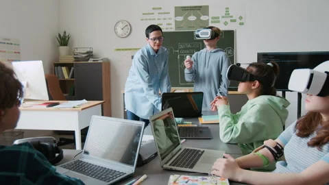 Teacher Teaching her Students to Use VR Glasses 스톡 동영상 317644058