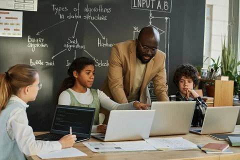 Teacher teaching students to use computers Stock Photos