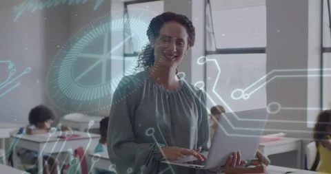 Teacher typing on laptop, activating circuit overlay drifting over class Stock Footage 329594446