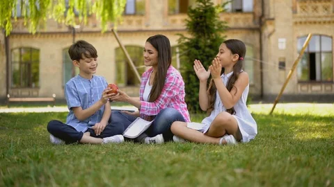 Teacher use apple as example in the lesson utdoors. Stock Footage 130048778