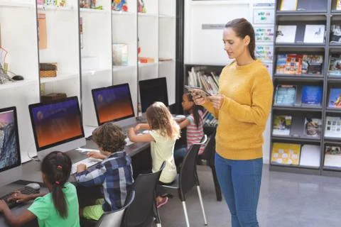 Teacher using digital tablet in computer room 스톡 사진