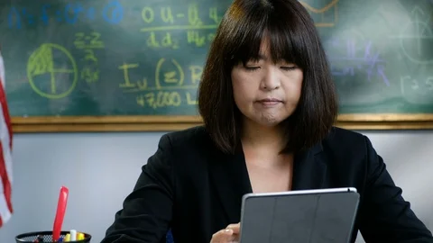 Teacher using an ipad/tablet in her classroom Stock Footage