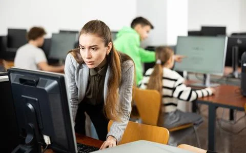 Teacher using personal computer during lesson in school Stockfoto's