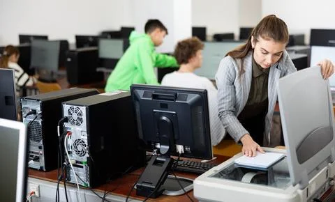 Teacher using scanner in computer class Foto stock