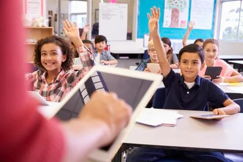 Teacher using tablet computer in elementary school lesson Stock Photos