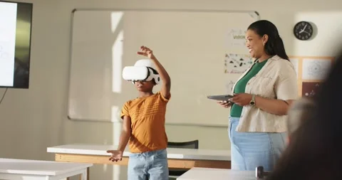 Teacher using tablet while African youth donning VR headset, reaching virtual Stock Footage 335070340
