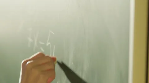 The teacher is utilizing a blackboard in the classroom to instruct students on Stock Footage 277932090