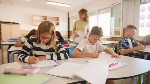 Teacher walking among students during a classroom lesson Stock Footage 345113681