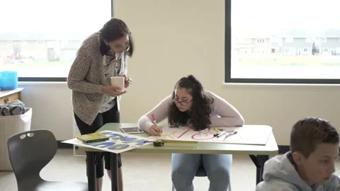 Teacher watching student make poster in classroom Stock-Footage 221035526