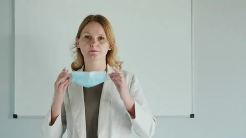 Teacher wears protective mask in front of classroom Stock Footage 130585356