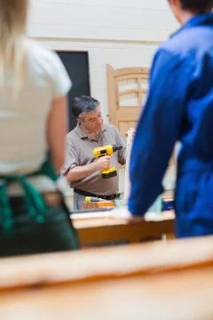 Teacher of a woodworking class explaining Stock Photos