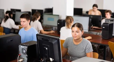 Teacher works at computer in the classroom. Students doing programming Stock Photos