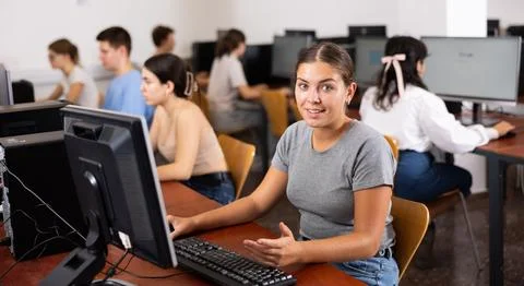 Teacher works at computer in the classroom. Students doing programming Stock Photos
