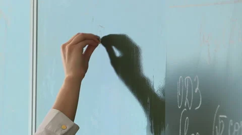 Teacher writes with chalk on a blackboard Stock Footage