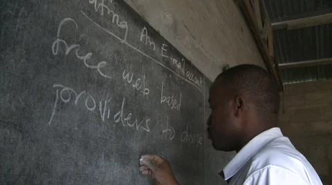 TEACHER WRITING ON BOARD - PAN TO STUDENTS IN CLASSROOM Stock Footage 60116028