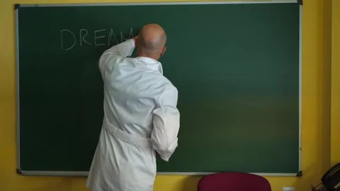 Teacher writing Dream Big Work Hard on chalkboard and showing to the class Stock Footage 341069169
