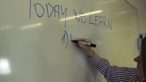Teacher writing a math lesson on a school whiteboard Stockbeeldmateriaal 345185516