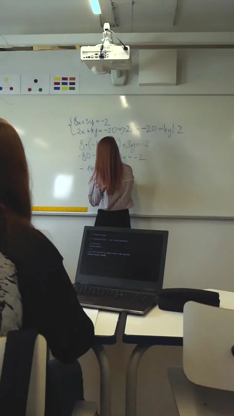 Teacher writing mathematical equations on classroom whiteboard Stock Footage 346597963
