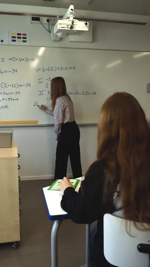Teacher writing mathematical formulas on whiteboard Stock Footage 345550805