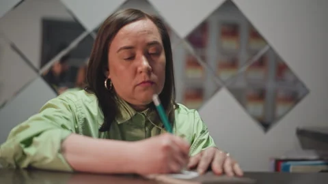 Teacher writing notes. Focused instructor composing educational material calmly Stock Footage 346552282