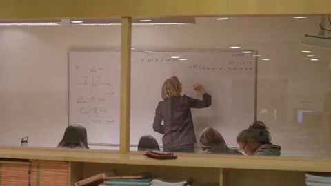 Teacher writing on white board - camera from window Stock Footage 81204088