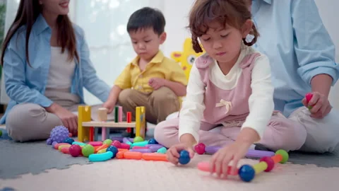 Teachers and parent playing joyfully with children, enhancing social Stock Footage 339583894
