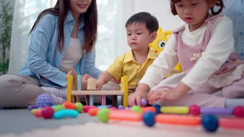 Teachers and parent playing joyfully with children, enhancing social Stock Footage 339583970