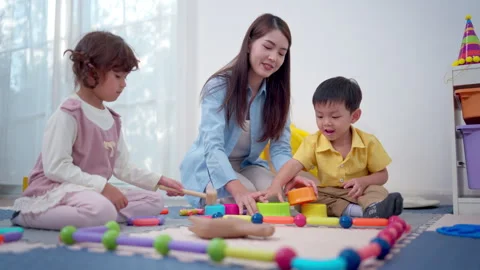 Teachers and parent playing joyfully with children, enhancing social Stock Footage 339584935