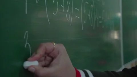 Teacher's hand writing maths assignment on green chalkboard for pupils in school Video stock 101400006