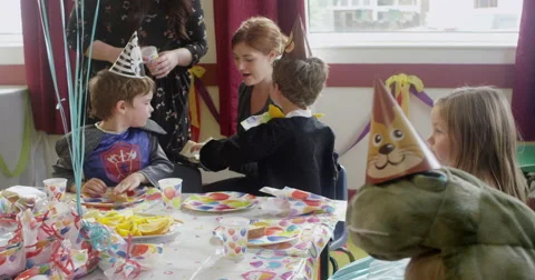 Teachers serving sandwiches to children at birthday party Stock Footage