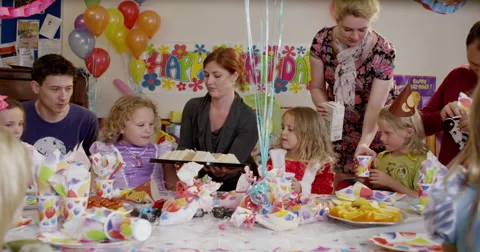 Teachers serving snacks and drinks to children at birthday party Stock Footage 58573822