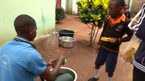 Teachers serving ugali and beans as lunch for students in rural school in Africa Stock Footage 230078492