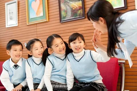 Teaching giving a high-five to young students Stock Photos