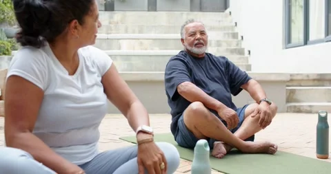 Teaching man in dark shirt placing hands on chest, guiding breathing on patio Stock Footage 336844952