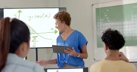 Teaching math, woman using tablet and explaining graph to students in high Stock Footage 299884790