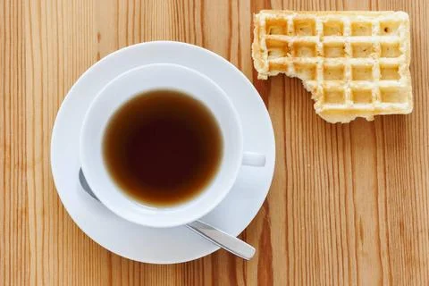 Teacup with biscuit on top right corner Wooden table with white cup with s... Stock Photos